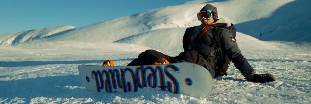 snowboarder à la station de la Pierre Saint-Martin qui fait une pause avec vue sur les sommets enneigés