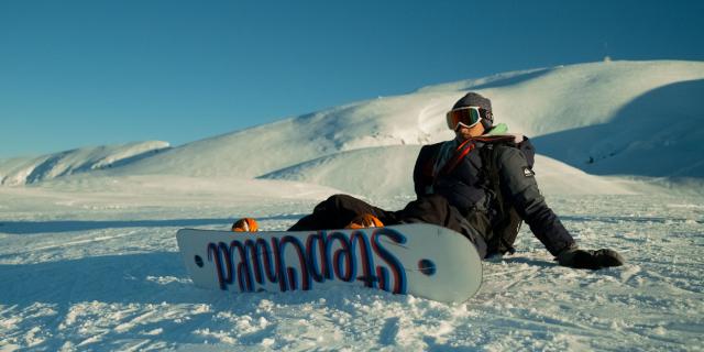 snowboarder à la station de la Pierre Saint-Martin qui fait une pause avec vue sur les sommets enneigés